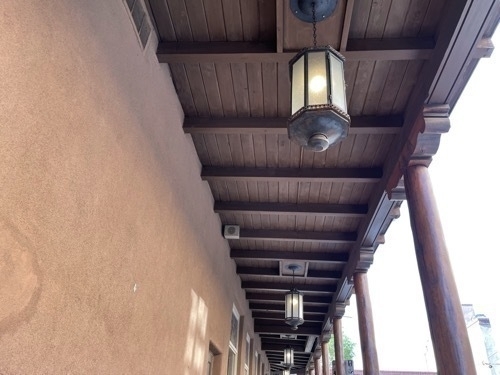 View of wooden posts supporting upper story along sidewalk in downtown Santa Fe New Mexico