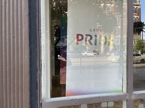 Corporate sign advertising Pride in storefront window in downtown Witchita Jansas