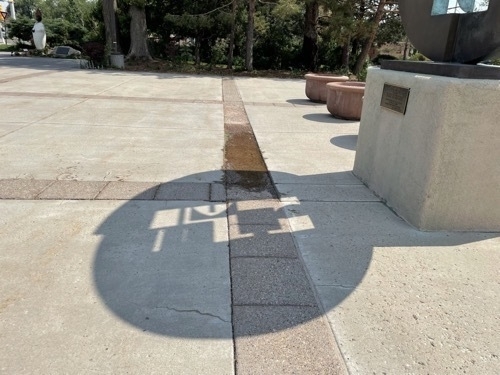 Circular shadow with inset projected by public art installation outside of New Mexico Capitol building